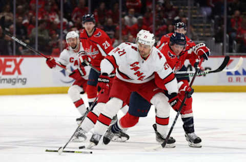 WASHINGTON, DC – MARCH 03: Nino Niederreiter #21 of the Carolina Hurricanes and Nic Dowd #26 of the Washington Capitals go after the puck in the first period at Capital One Arena on March 03, 2022, in Washington, DC. (Photo by Rob Carr/Getty Images)