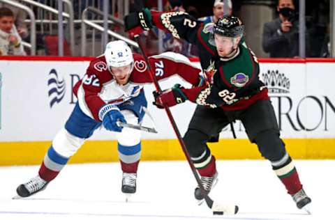 Jan 15, 2022; Glendale, Arizona, USA; Arizona Coyotes defenseman Janis Moser (62) moves the puck against Colorado Avalanche left wing Gabriel Landeskog (92) during the first period at Gila River Arena. Mandatory Credit: Mark J. Rebilas-USA TODAY Sports