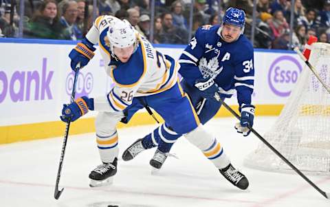 Nov 4, 2023; Toronto, Ontario, CAN; Buffalo Sabres defenseman Rasmus Dahlin (26) skates the puck away from Toronto Maple Leafs forward Auston Matthews (34) in the third period at Scotiabank Arena. Mandatory Credit: Dan Hamilton-USA TODAY Sports