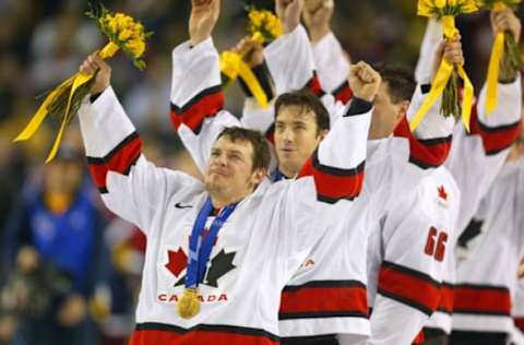 24 Feb 2002: Theo Fleury #74 and Joe Sakic #91 of Canada celebrate after receiving their gold medals. (Photo by: Al Bello/Getty Images)