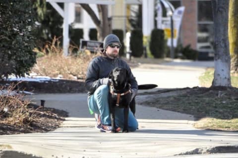 Seeing Eye instructor Brian O'Neal with a black Lab he trained.