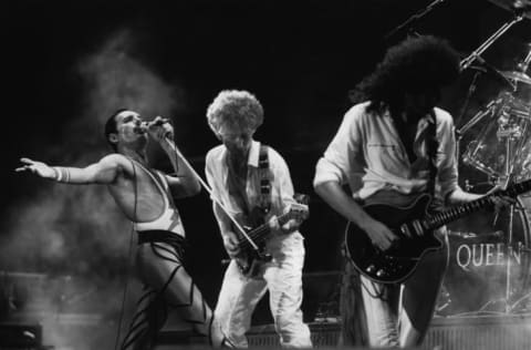 Freddie Mercury, John Deacon, and Brian May of British rock group Queen in concert in 1984.