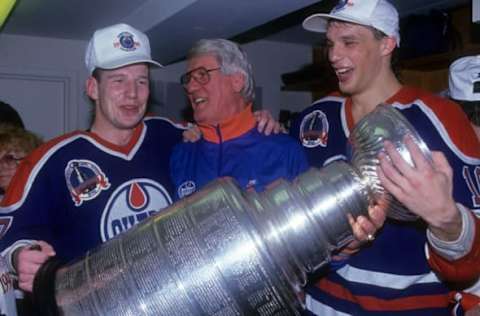 BOSTON, MA – MAY 24: Mark Lamb #7, designated co-coach John Muckler and Kelly Buchberger #16 of the Edmonton Oilers celebrate with the Stanley Cup in the locker room after the Oilers defeated the Boston Bruins in Game 5 of the 1990 Stanley Cup Finals on May 24, 1990 at the Boston Garden in Boston, Massachusetts. (Photo by B Bennett/Getty Images)