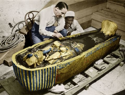 English Egyptologist Howard Carter examines the golden sarcophagus of King Tutankhamun in Egypt in 1923.