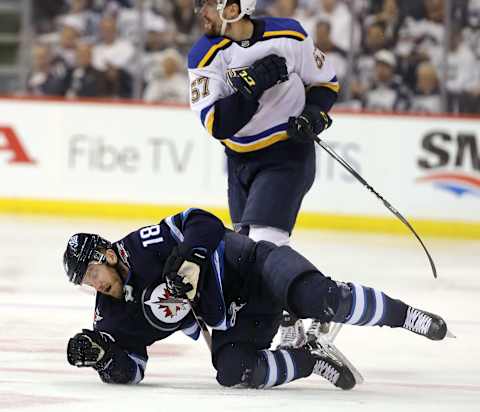 WINNIPEG, MANITOBA – APRIL 18: Bryan Little #18 of the Winnipeg Jets gets up from the ice after a check from David Perron #57 of the St. Louis Blues in Game Five of the Western Conference First Round during the 2019 NHL Stanley Cup Playoffs at Bell MTS Place on April 18, 2019 in Winnipeg, Manitoba, Canada. (Photo by Jason Halstead/Getty Images)