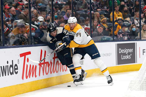 Dec 30, 2021; Columbus, Ohio, USA; Nashville Predators left wing Tanner Jeannot (84) checks Columbus Blue Jackets center Jack Roslovic (96) during the first period at Nationwide Arena. Mandatory Credit: Russell LaBounty-USA TODAY Sports