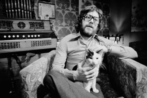 Publisher, poet, and future Mental Floss owner Felix Dennis with a cat in 1976.