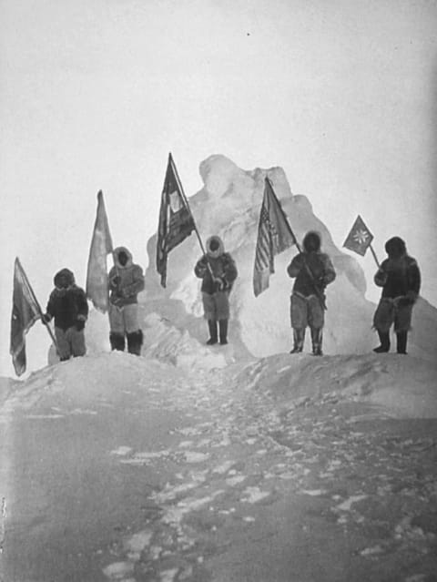 (L-R) Ooqueah, Ootah, Matthew Henson, Egingwah, and Seegloo hold Peary's expedition flags at the what they believe it the North Pole in 1909.