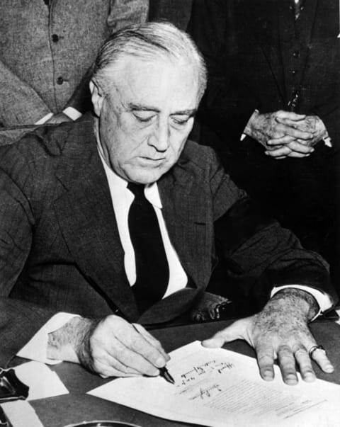 President Franklin D. Roosevelt signing the declaration of war against Japan.