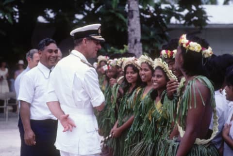 Prince Philip chats to local children in native dress on the island of Kiribati in 1983, during the Royal Tour of the South Pacific.