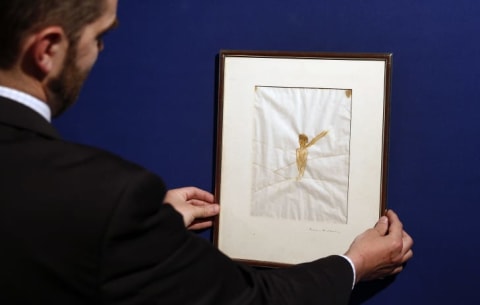 An employee presents a drawing from Antoine de Saint-Exupery that was to be sold by the auction house Artcurial in Paris, France.