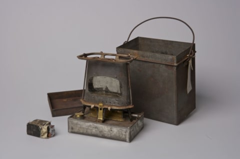 Robert Peary designed and patented this stove, which was fueled by alcohol and used in food preparation and for providing warmth during the expeditions to the North Pole. Its tin container and matches are also shown.