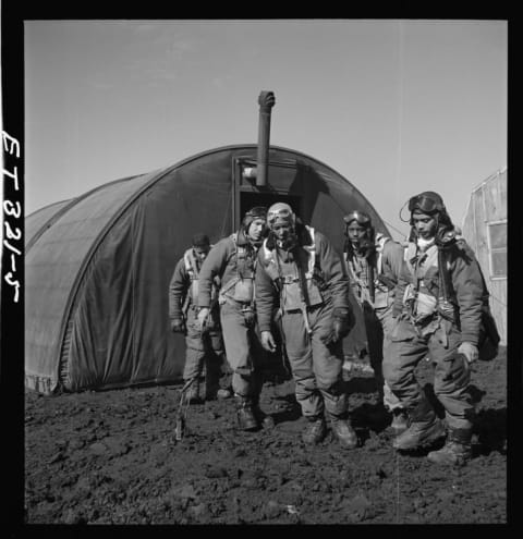 Tuskegee Airmen (left to right) Richard S. "Rip" Harder, unidentified airman, Thurston L. Gaines, Jr., Newman C. Golden, and Wendell M. Lucas leave the parachute room in Ramitelli, Italy, in March 1945.