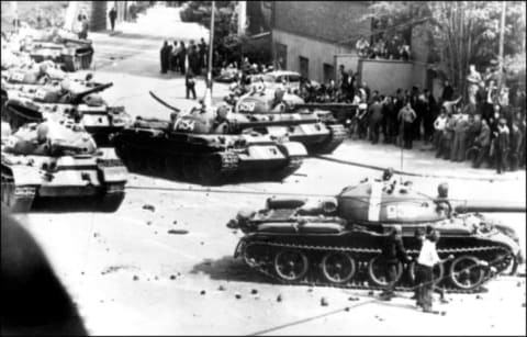 Prague residents throw rocks at Soviet tanks entering the city in 1968.