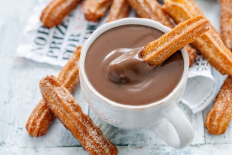 Churros accompanied by chocolate.