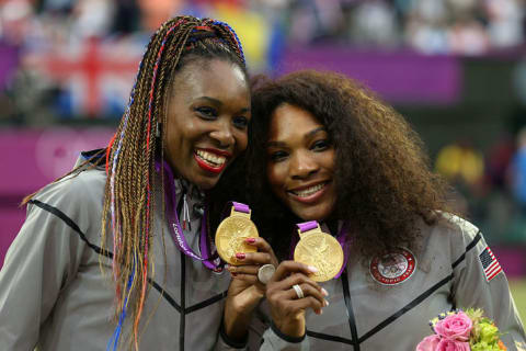 Serena and Venus Williams show off their matching gold medals at the London 2012 Olympic Games.