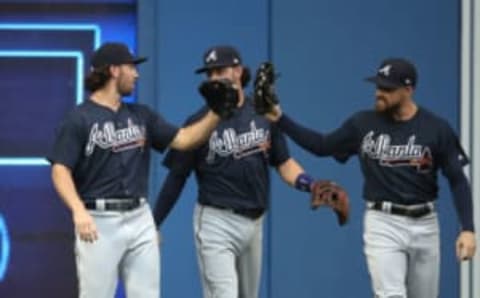 TORONTO, ON – JUNE 19: Charlie Culberson #16 (L) of the Atlanta Braves is congratulated by Ender Inciarte #11 (R) and Dansby Swanson #7 (C) after making a catch and crashing into the wall in the first inning during MLB game action against the Toronto Blue Jays at Rogers Centre on June 19, 2018 in Toronto, Canada. (Photo by Tom Szczerbowski/Getty Images)