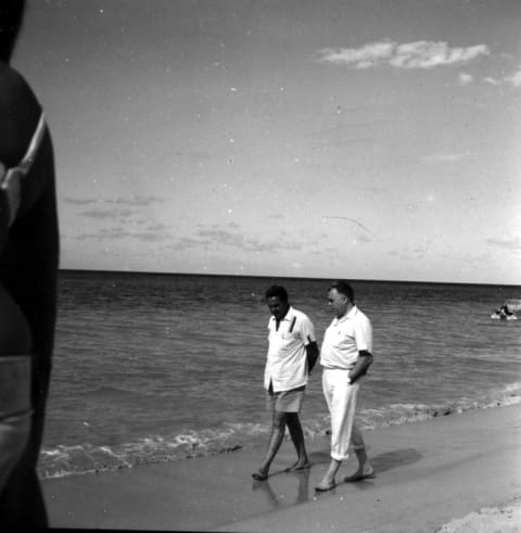 Cubby Broccoli and Harry Saltzman chatting on a beach in Jamaica.