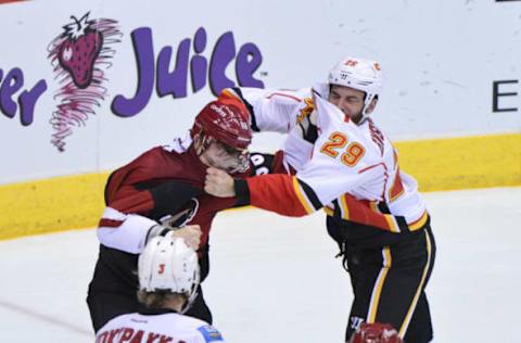 Dec 19, 2016; Glendale, AZ, USA; Arizona Coyotes left wing Jamie McGinn (88) and Calgary Flames defenseman Deryk Engelland (29) fight during the second period at Gila River Arena. Mandatory Credit: Matt Kartozian-USA TODAY Sports