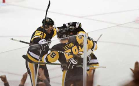 PITTSBURGH, PENNSYLVANIA – FEBRUARY 15: Evgeni Malkin #71 and Kris Letang #58 celebrate with Sidney Crosby #87 of the Pittsburgh Penguins after Crosby scored his 500th NHL goal during the first period against the Philadelphia Flyers at PPG PAINTS Arena on February 15, 2022 in Pittsburgh, Pennsylvania. (Photo by Emilee Chinn/Getty Images)