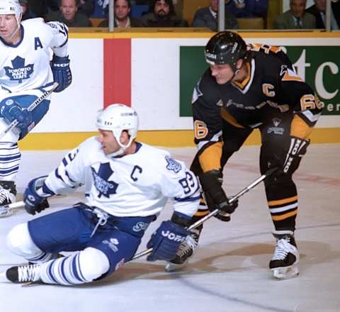 Mario Lemieux #66 of the Pittsburgh Penguins takes down Doug Gilmour #93 of the Toronto Maple Leafs on February 12, 1996 at Maple Leaf Gardens in Toronto (Photo by Graig Abel/Getty Images)