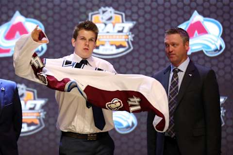 Jun 27, 2014; Philadelphia, PA, USA; Conner Bleackley (left) puts on a team sweater in front of head coach Patrick Roy after being selected as the number twenty-three overall pick to the Colorado Avalanche in the first round of the 2014 NHL Draft at Wells Fargo Center. Mandatory Credit: Bill Streicher-USA TODAY Sports