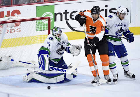 Dec 17, 2015; Philadelphia, PA, USA; Philadelphia Flyers left wing R.J. Umberger (20) and Vancouver Canucks defenseman Yannick Weber (6) battle for rebound in front of goalie Jacob Markstrom (25) during the third period at Wells Fargo Center. The Flyers defeated the Canucks, 2-0. Mandatory Credit: Eric Hartline-USA TODAY Sports