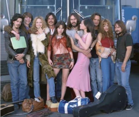 The cast of Almost Famous (2000) poses in front of the Stillwater tour bus.