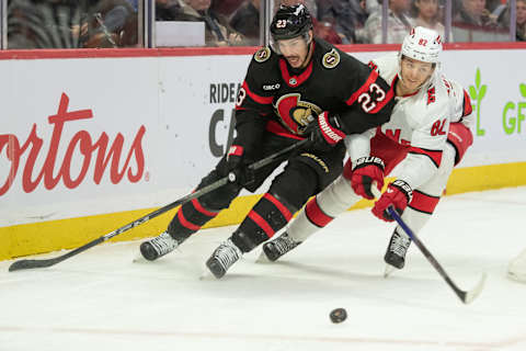 Dec 12, 2023; Ottawa, Ontario, CAN; Ottawa Senators defenseman Travis Hamonic (23) battles with Carolina Hurricanes center Jesperi Kotkaniemi (82) in the second period at the Canadian Tire Centre. Mandatory Credit: Marc DesRosiers-USA TODAY Sports