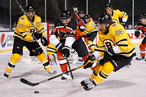 STATELINE, NEVADA – FEBRUARY 21: David Pastrnak #88 of the Boston Bruins skates with the puck pressured by Sean Couturier #14 of the Philadelphia Flyers during the ‘NHL Outdoors At Lake Tahoe’ at the Edgewood Tahoe Resort on February 21, 2021 in Stateline, Nevada. The Bruins defeated the Flyers 7-3. (Photo by Christian Petersen/Getty Images)