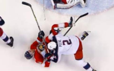 SUNRISE, FL – FEBRUARY 24: Sam Bennett #9 of the Florida Panthers is checked to the ice by Andrew Peeke #2 of the Columbus Blue Jackets in front of the goal crease at the FLA Live Arena on February 24, 2022 in Sunrise, Florida. (Photo by Joel Auerbach/Getty Images)