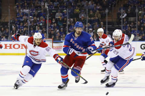 Chris Kreider #20 of the New York Rangers skates away from Andrew Shaw #65 (Photo by Bruce Bennett/Getty Images)