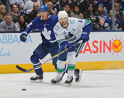 TORONTO, ON – FEBRUARY 29: Christopher Tanev #8 of the Vancouver Canucks skates after the puck against Kasperi Kapanen #24 of the Toronto Maple Leafs  . (Photo by Claus Andersen/Getty Images)