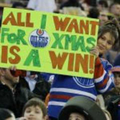 Dec 23, 2014; Edmonton, Alberta, CAN; Edmonton Oilers fan holds up a sign  Rexall Place. Mandatory Credit: Perry Nelson-USA TODAY Sports