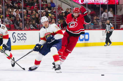 Dec 21, 2019; Raleigh, North Carolina, USA; Carolina Hurricanes center Jordan Staal (11) tries to slip the puck past the defense of Florida Panthers defenseman Anton Stralman (6) during the second period at PNC Arena. Mandatory Credit: James Guillory-USA TODAY Sports