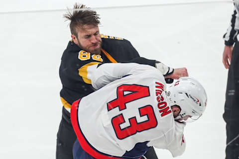 Mar 5, 2021; Boston, Massachusetts, USA; Boston Bruins defenseman Jarred Tinordi (84) punches Washington Capitals right wing Tom Wilson (43) during the second period at TD Garden. Mandatory Credit: Paul Rutherford-USA TODAY Sports