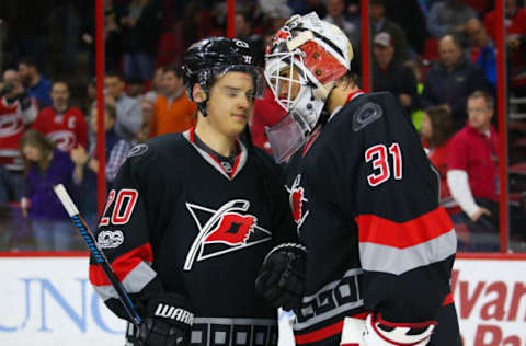 Mar 16, 2017; Raleigh, NC, USA; Carolina Hurricanes goalie Eddie Lack (31) and Carolina Hurricanes forward Sebastian Aho (20) celebrates there victory against the Minnesota Wild at PNC Arena. The Carolina Hurricanes defeated the Minnesota Wild 3-1. Mandatory Credit: James Guillory-USA TODAY Sports