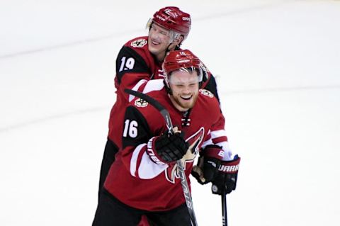 Feb 18, 2016; Glendale, AZ, USA; Arizona Coyotes right wing Shane Doan (19) and center Max Domi (16) celebrate after beating the Dallas Stars 6-3 at Gila River Arena. Mandatory Credit: Matt Kartozian-USA TODAY Sports