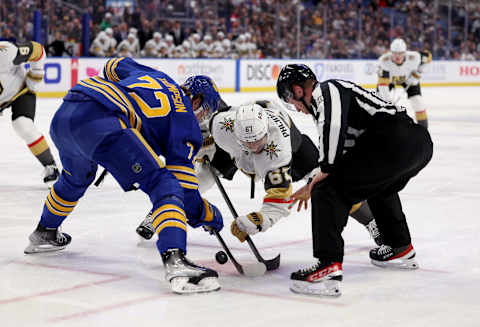 Mar 10, 2022; Buffalo, New York, USA; NHL linesman Tyson Baker (88) drops the puck for a face-off between Buffalo Sabres right wing Tage Thompson (72) and Vegas Golden Knights left wing Max Pacioretty (67) during the first period at KeyBank Center. Mandatory Credit: Timothy T. Ludwig-USA TODAY Sports