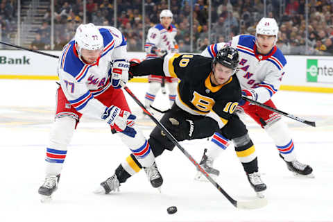 BOSTON, MASSACHUSETTS – NOVEMBER 29: Tony DeAngelo #77 of the New York Rangers and Anders Bjork #10 of the Boston Bruins battle for control of the puck during the first period at TD Garden on November 29, 2019 in Boston, Massachusetts. (Photo by Maddie Meyer/Getty Images)