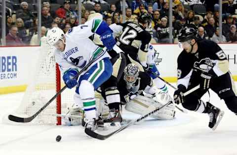 Jan 23, 2016; Pittsburgh, PA, USA; Vancouver Canucks right wing Linden Vey (7) handles the puck as Pittsburgh Penguins goalie Marc-Andre Fleury (29) and defenseman Kris Letang (58) defend during the first period at the CONSOL Energy Center. Mandatory Credit: Charles LeClaire-USA TODAY Sports