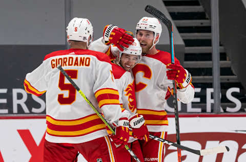 VANCOUVER, BC – FEBRUARY 13: Sam Bennett #93 of the Calgary Flames celebrates with teammates Johnny Gaudreau #13 and Mark Giordano #5 after scoring a goal against the Vancouver Canucks during NHL hockey action at Rogers Arena on February 13, 2021 in Vancouver, Canada. (Photo by Rich Lam/Getty Images)