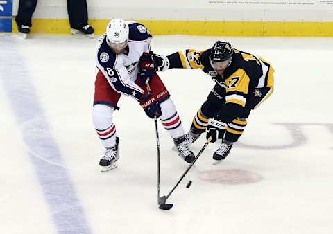 Apr 4, 2017; Pittsburgh, PA, USA; Columbus Blue Jackets defenseman David Savard (58) and Pittsburgh Penguins right wing Bryan Rust (17) reach for the puck during the second period at the PPG PAINTS Arena. Mandatory Credit: Charles LeClaire-USA TODAY Sports