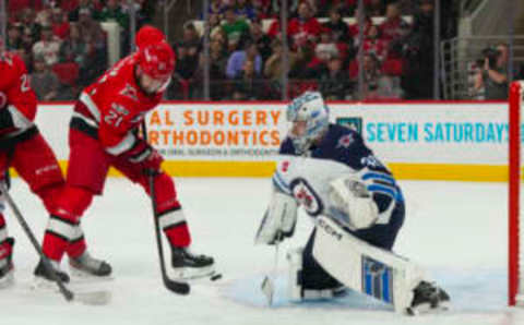 Mar 14, 2023; Raleigh, North Carolina, USA; Carolina Hurricanes center Derek Stepan (21) tips a shot against Winnipeg Jets goaltender David Rittich (33) during the first period at PNC Arena. Mandatory Credit: James Guillory-USA TODAY Sports