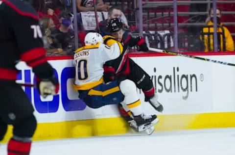 May 17, 2021; Raleigh, North Carolina, USA; Carolina Hurricanes center Vincent Trocheck (16) checks Nashville Predators center Colton Sissons (10) during the first period in game one of the first round of the 2021 Stanley Cup Playoffs at PNC Arena. Mandatory Credit: James Guillory-USA TODAY Sports