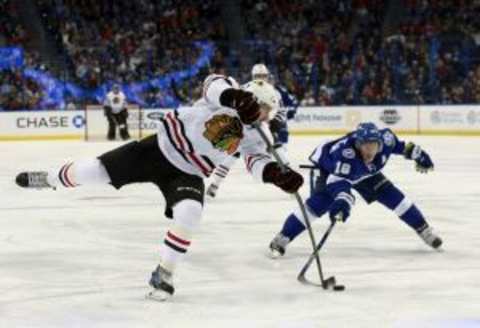 Jan 21, 2016; Tampa, FL, USA; Chicago Blackhawks left wing Phillip Danault (24) shoots as Tampa Bay Lightning left wing Ondrej Palat (18) defends during the third period at Amalie Arena. Tampa Bay Lightning defeated the Chicago Blackhawks 2-1. Mandatory Credit: Kim Klement-USA TODAY Sports