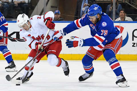 Apr 12, 2022; New York, New York, USA; Carolina Hurricanes center Seth Jarvis (24) skates with the puck defended by New York Rangers defenseman K’Andre Miller (79) during the second period at Madison Square Garden. Mandatory Credit: Dennis Schneidler-USA TODAY Sports