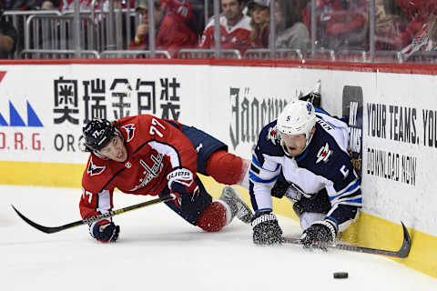 WASHINGTON, DC – MARCH 10: T.J. Oshie #77 of the Washington Capitals and Dmitry Kulikov #5 of the Winnipeg Jets battle for the puck in the first period at Capital One Arena on March 10, 2019 in Washington, DC. (Photo by Patrick McDermott/NHLI via Getty Images)