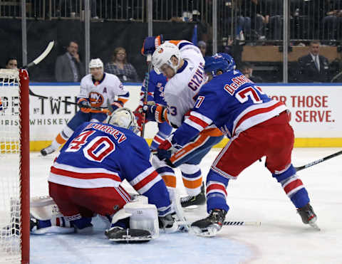 Alexandar Georgiev #40 and Tony DeAngelo #77 of the New York Rangers defend the net against Casey Cizikas #53 of the New York Islanders