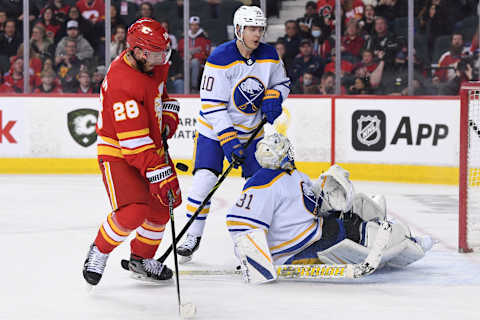 Mar 18, 2022; Calgary, Alberta, CAN; Calgary Flames forward Elias Lindholm (28) and Buffalo Sabres defenseman Henri Jokiharju (10) and goalie Dustin Tokarski (31) react to a shot on net in the third period at Scotiabank Saddledome.Sabres won 1-0. Mandatory Credit: Candice Ward-USA TODAY Sports